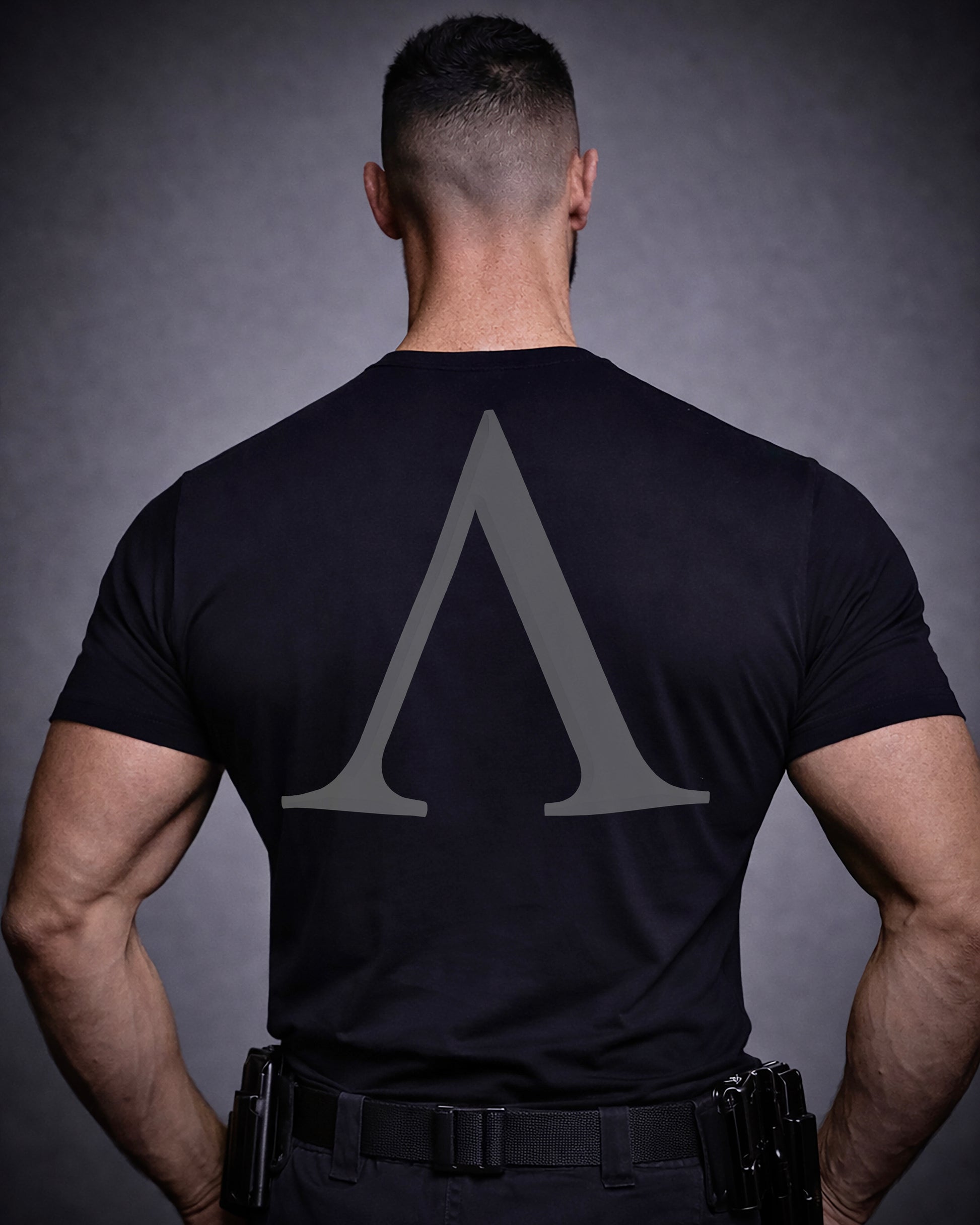 Back view of man wearing black Achilles T-shirt printed with Large Lambda mark logo on back