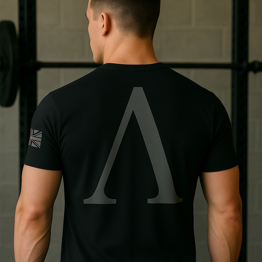Back view of man wearing Black short sleeve unisex fit original cotton T-Shirt by Achilles Tactical Clothing Brand printed with A Brand design across back