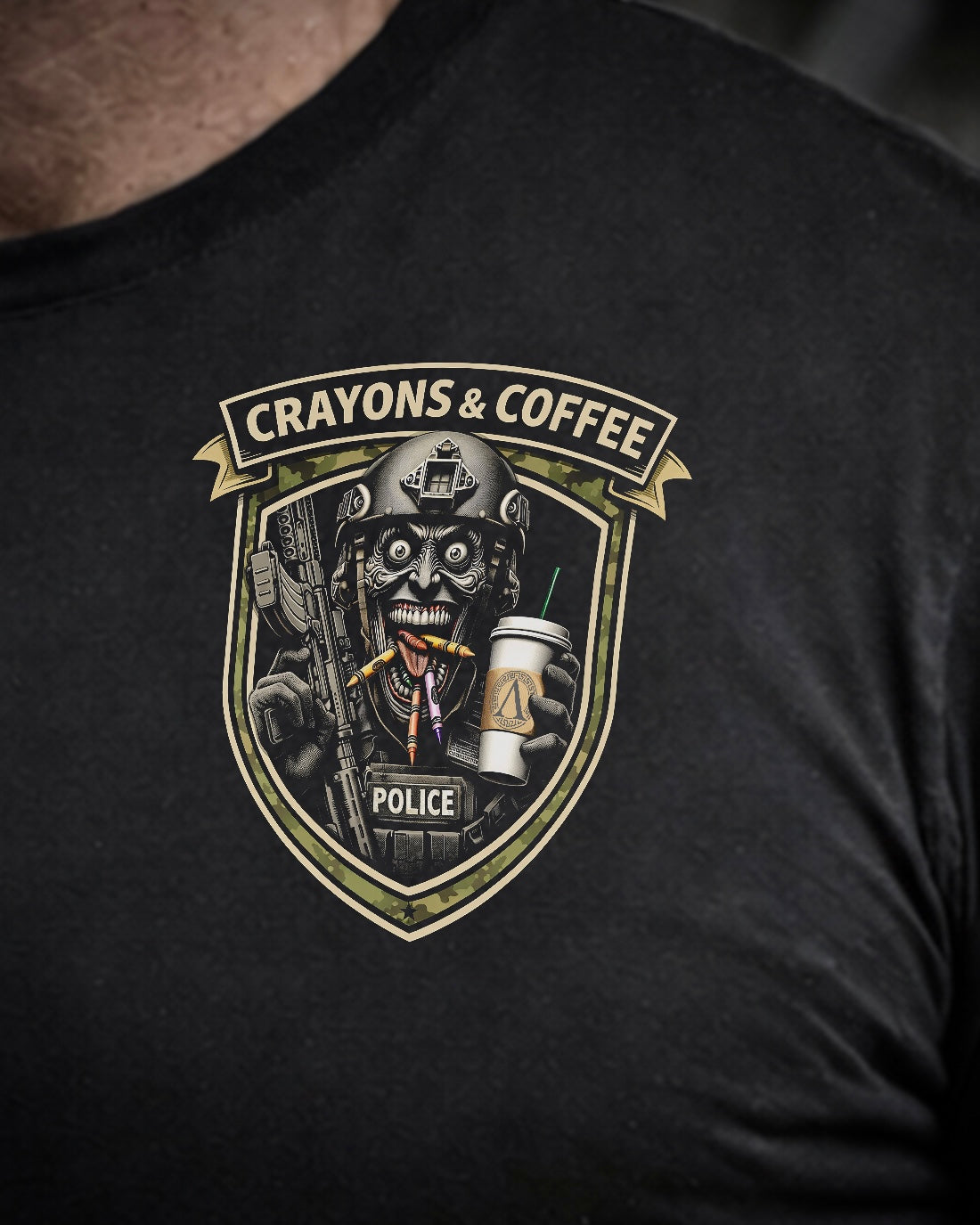 Close up of front view of man wearing black Achilles T-shirt printed with Crayons and Coffee logo on chest