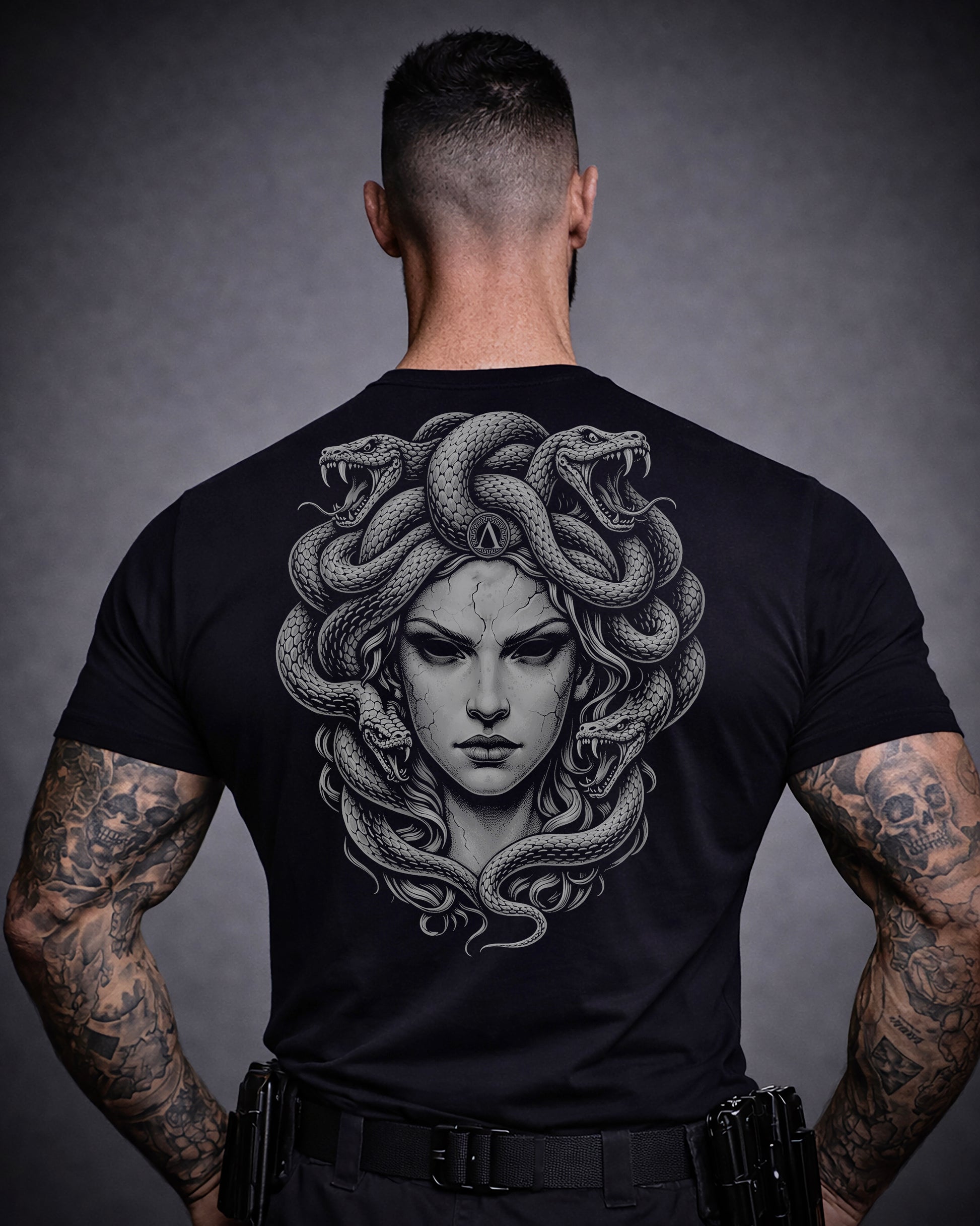 Back view of man wearing black Achilles T-shirt printed with large Medusa logo on back