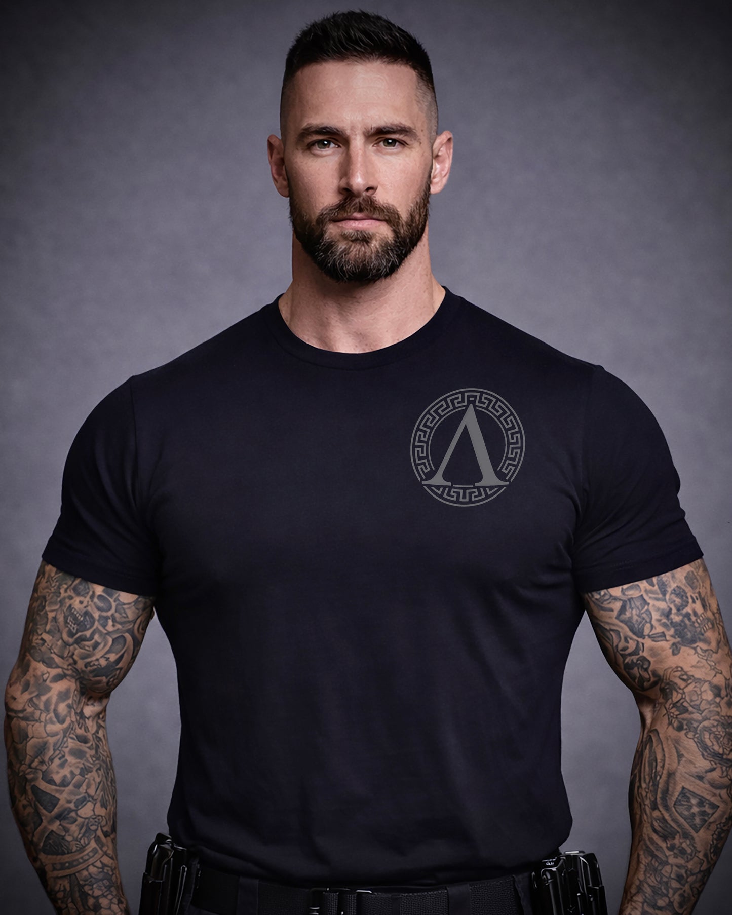 Front view of man wearing black Achilles T-shirt printed with Roundel logo on front chest