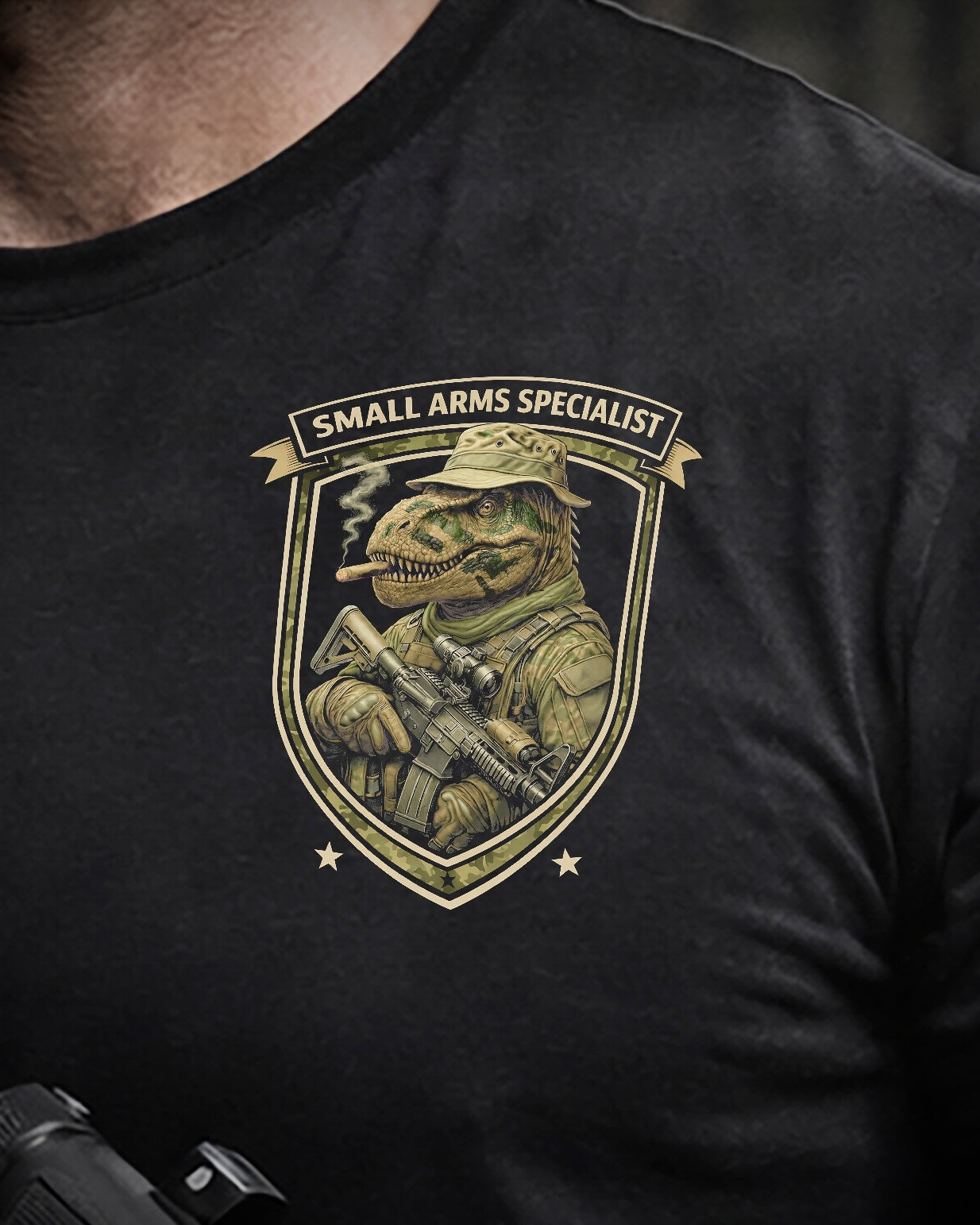 Close up of front view of man wearing black Achilles T-shirt printed with Small Arms Specialist  logo on chest