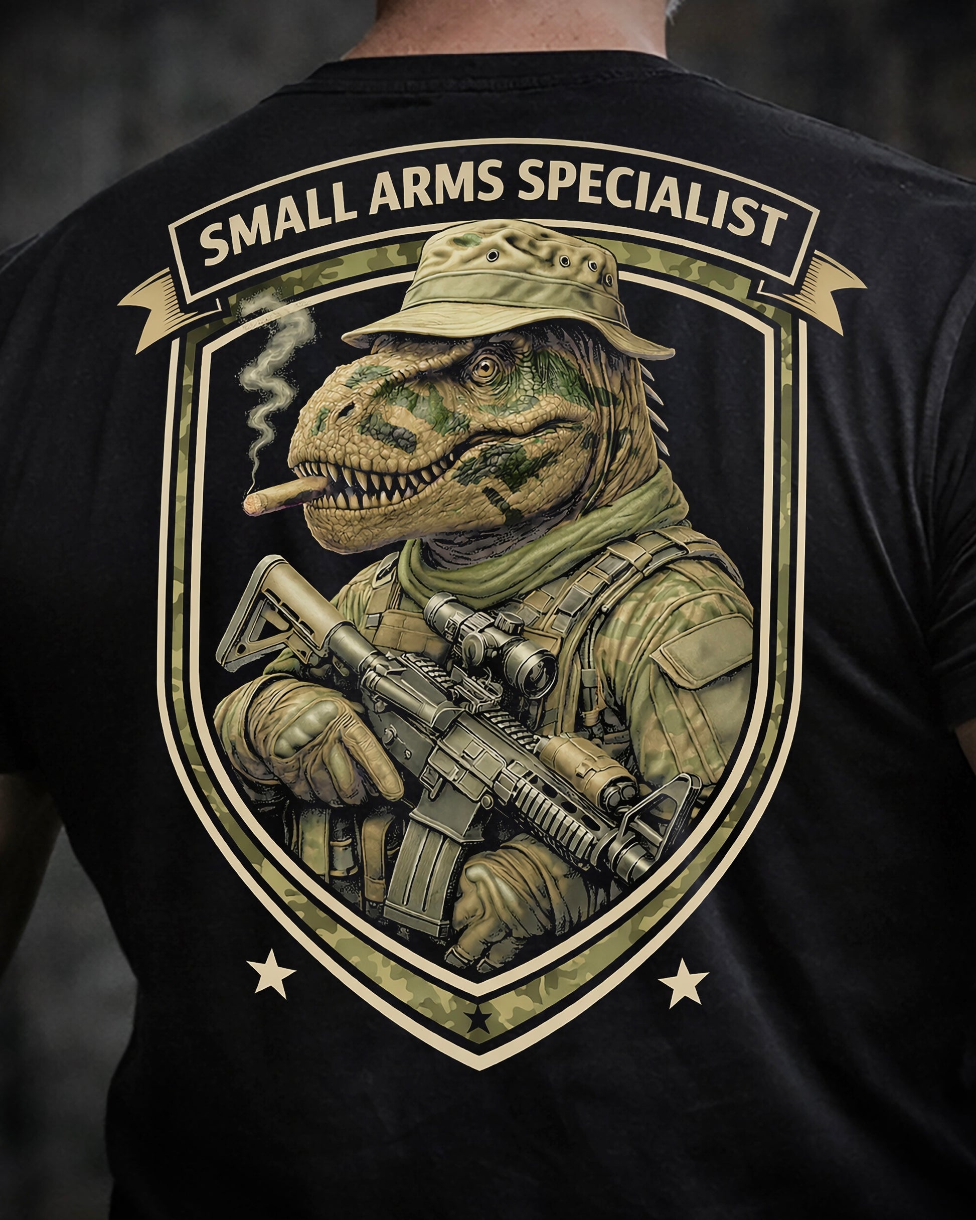Close up of back view of man wearing black Achilles T-shirt printed with Small Arms Specialist  logo on back
