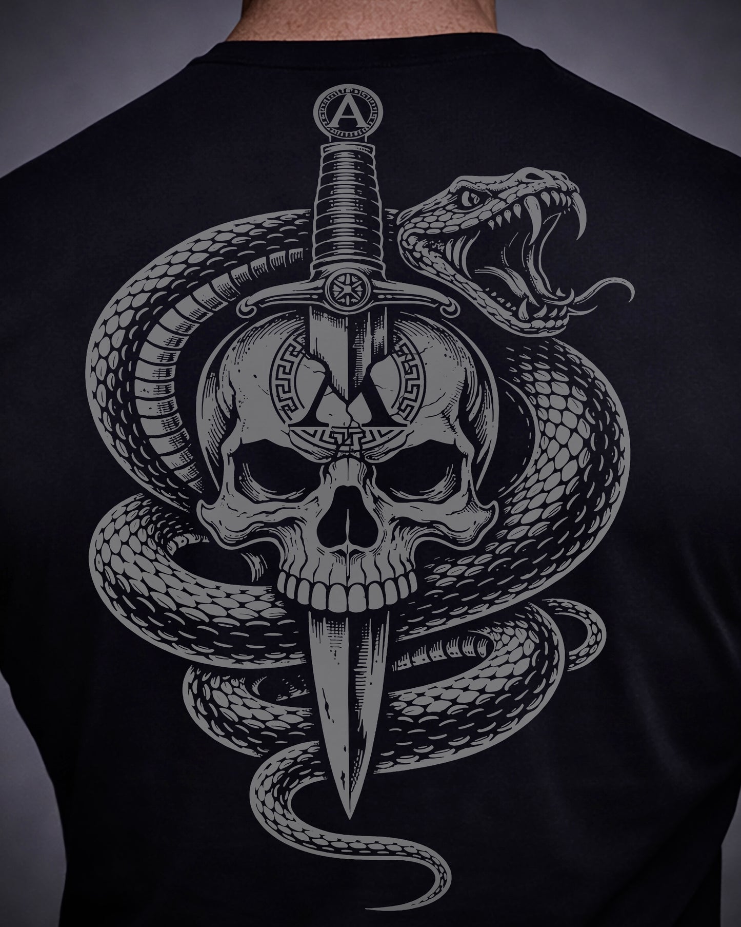 Close up of back view of man wearing black Achilles T-shirt printed with Large Venom logo on back