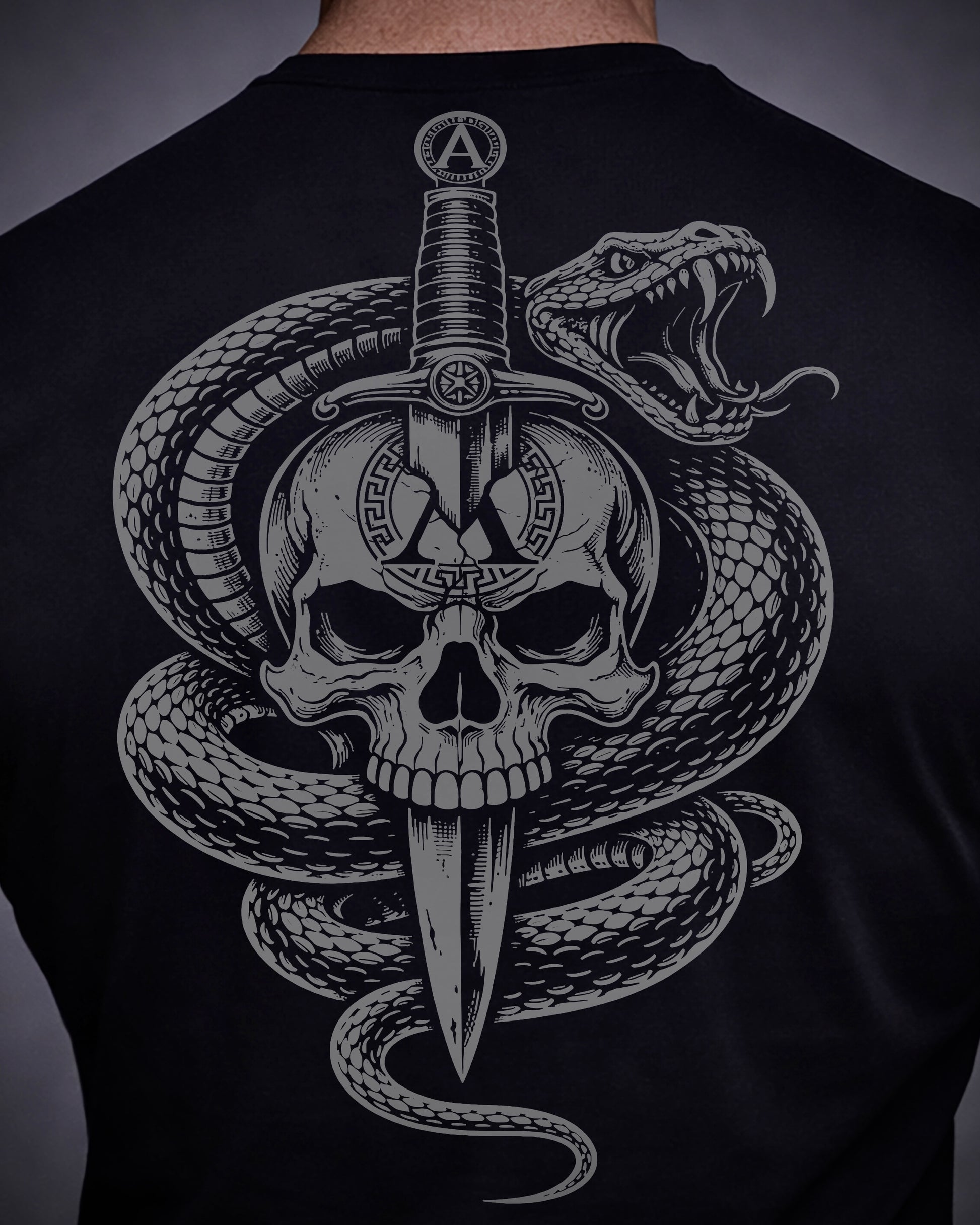 Close up of back view of man wearing black Achilles T-shirt printed with Large Venom logo on back