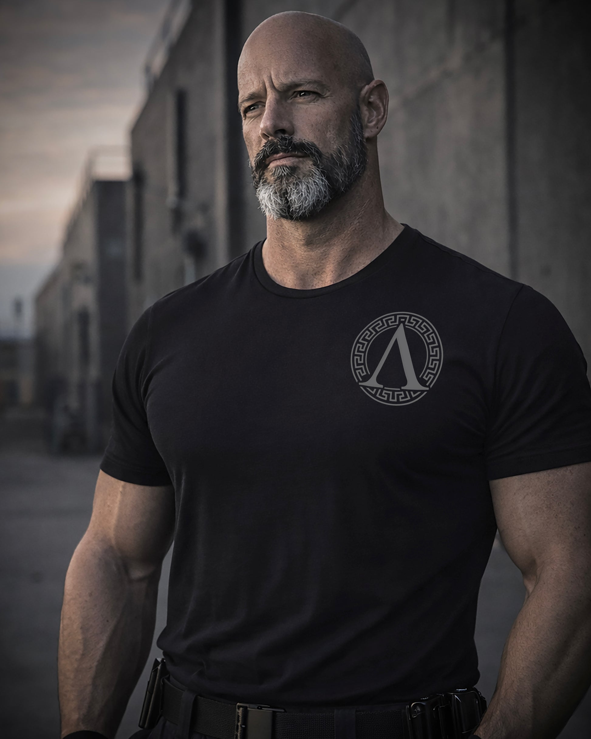 Front view of man wearing black Achilles T-shirt printed with Roundel logo on front chest